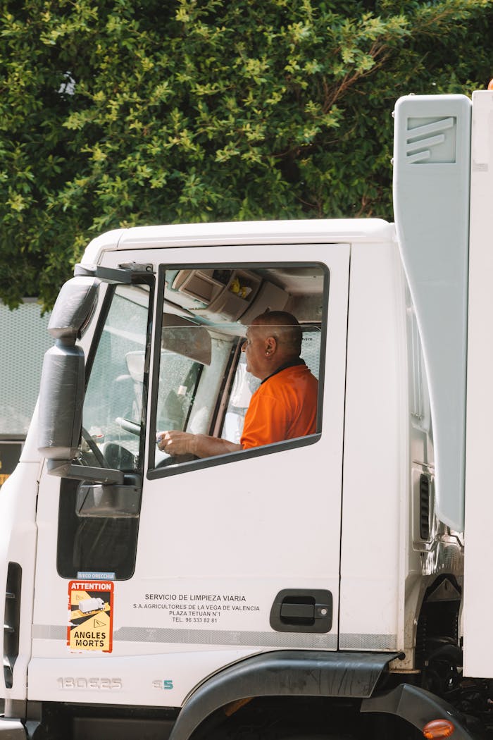Driver in an urban truck, servicing streets in Valencia.